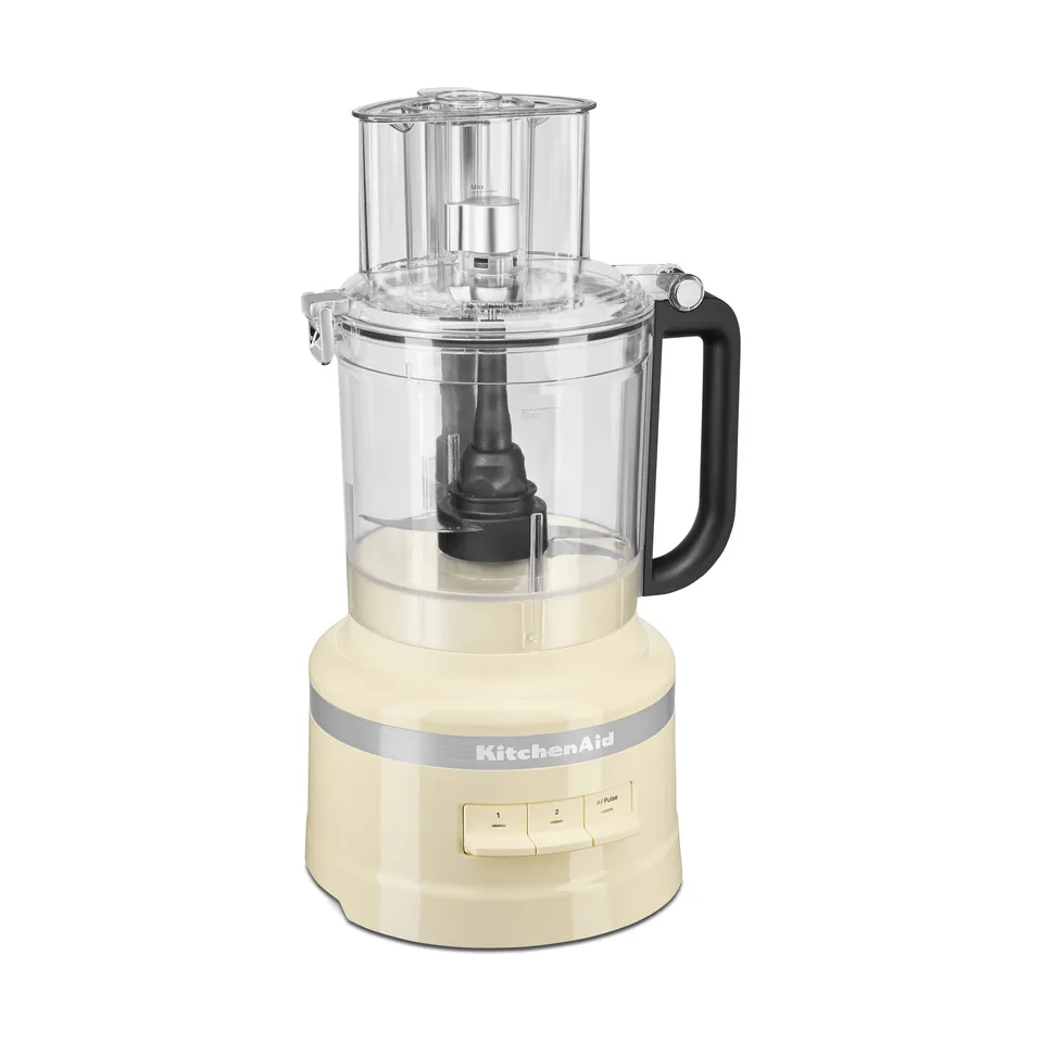 Cremefarvet foodprocessor med stor gennemsigtig skål og sort håndtag, på hvid baggrund