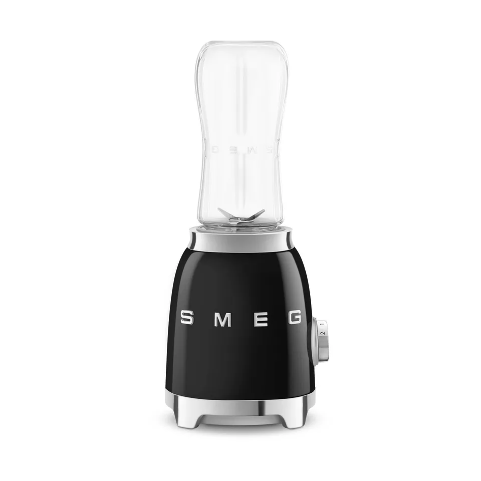 Sort retroblender med krom SMEG-skrift og en klar flaske sat på som kande, på hvid baggrund
