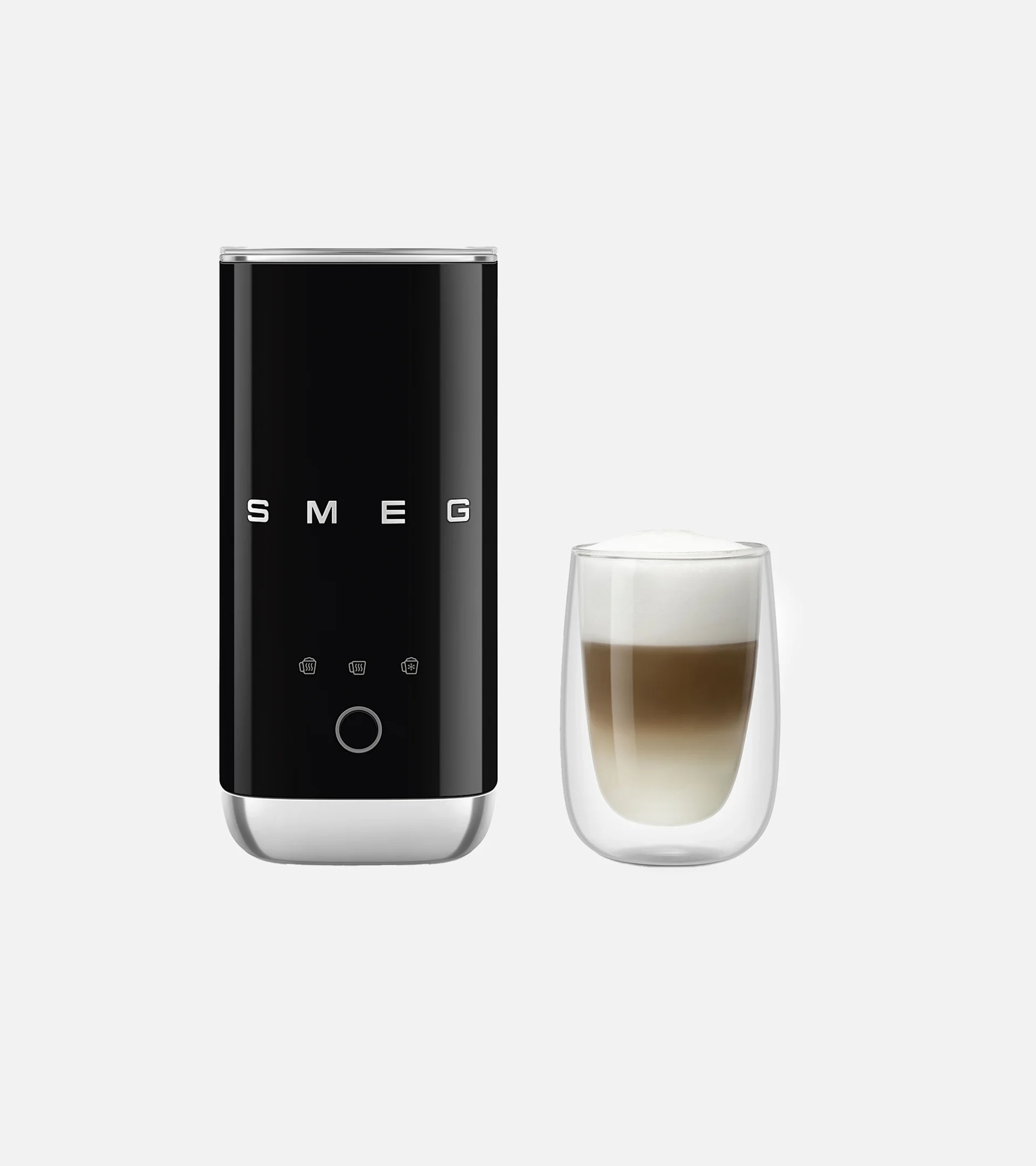 Sort Smeg mælkeskummer ved siden af et glas lagdelt kaffe med skum.