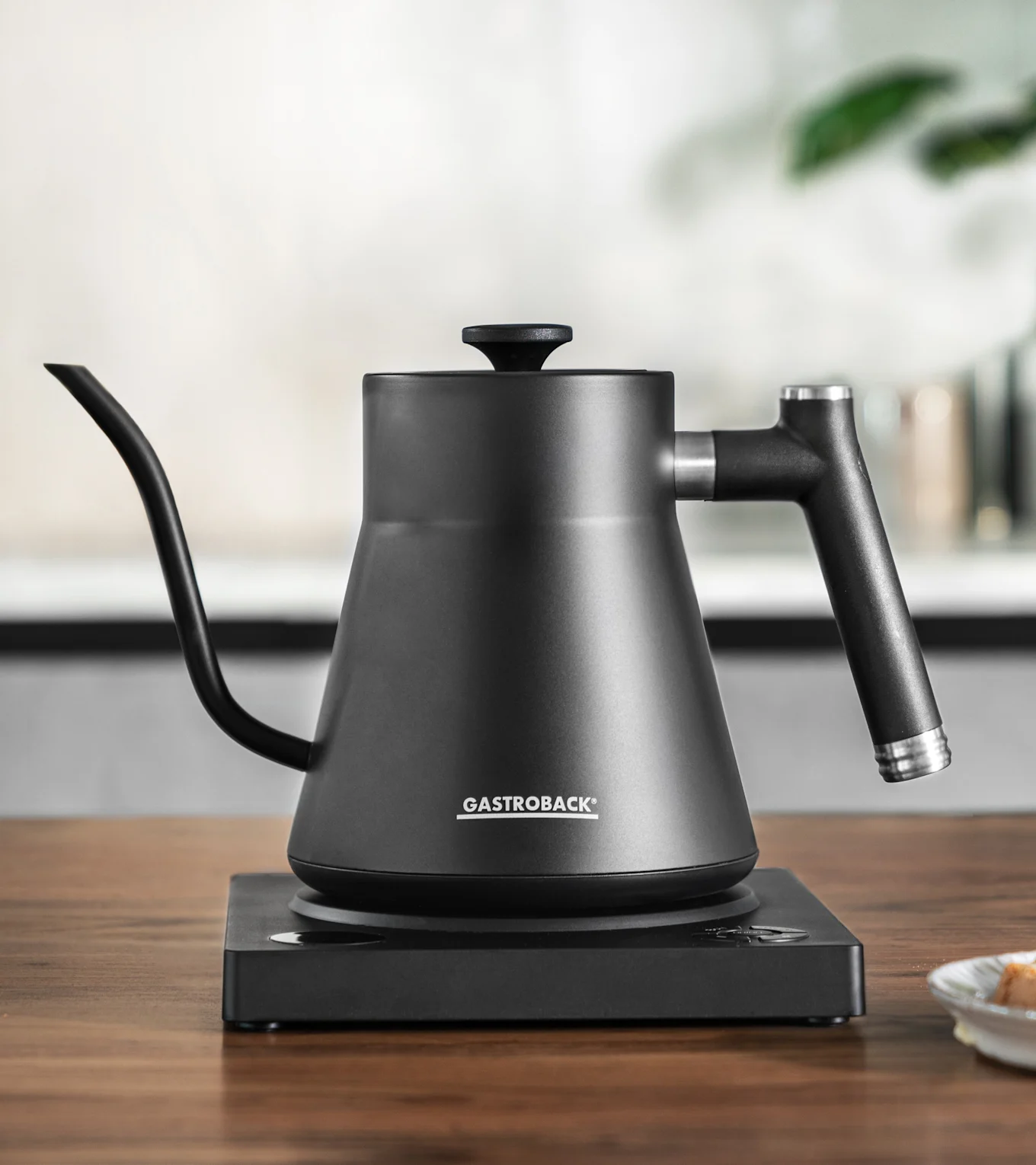 Mat sort pour-over kedel med svanehalstud på en matchende elektrisk base.