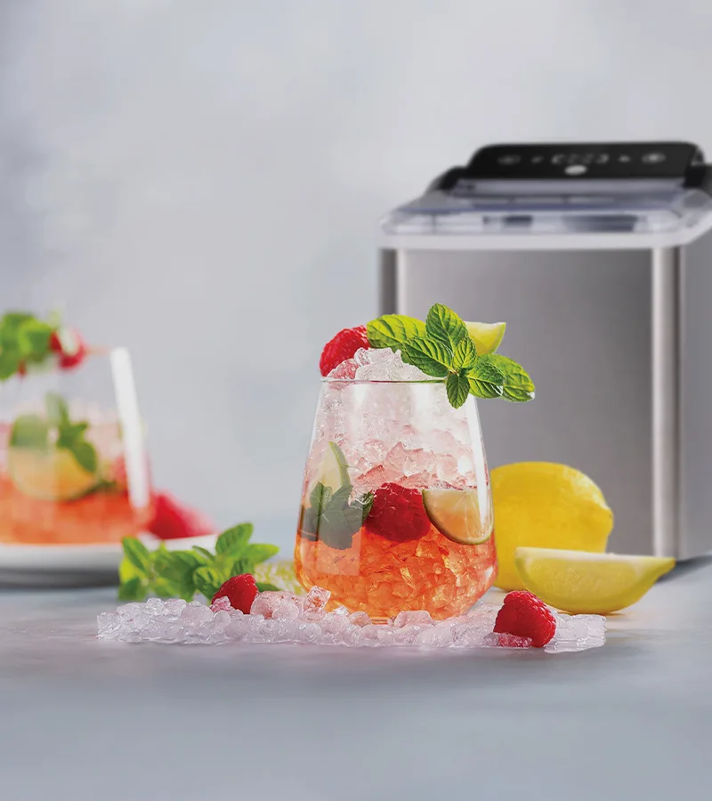 Forfriskende drink med knust is, hindbær, lime, mynte, en ismaskine og spredt is med citron.