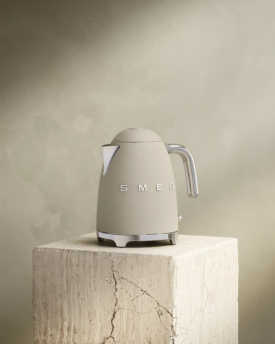 Beige Smeg elkedel med kromdetaljer på en tekstureret stenblok.
